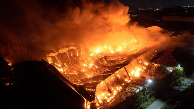 Foto udara kobaran api yang membakar kompleks pabrik pengolahan pupuk CV Saprotan Utama di Desa Bandungrejo, Mranggen, Demak, Jawa Tengah, Kamis (21/7/2022).  ANTARA FOTO/Aji Styawan
