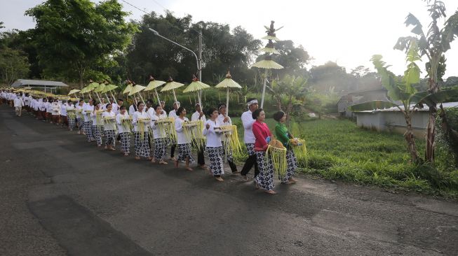 Warga membawa padi sebagai simbol kebersamaan saat perayaan adat Seren taun di Cigugur, Kuningan, Jawa Barat, Jumat (22/7/2022).  ANTARA FOTO/Dedhez Anggara