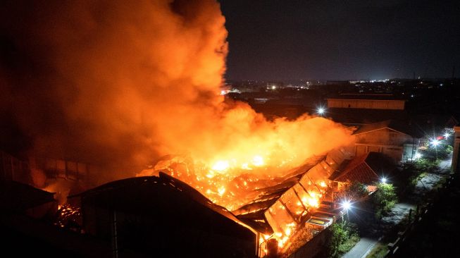 Foto udara kobaran api yang membakar kompleks pabrik pengolahan pupuk CV Saprotan Utama di Desa Bandungrejo, Mranggen, Demak, Jawa Tengah, Kamis (21/7/2022).  ANTARA FOTO/Aji Styawan
