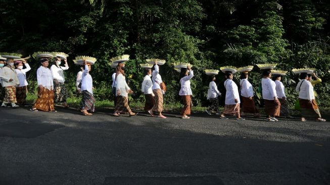 Warga membawa padi sebagai simbol kebersamaan saat perayaan adat Seren taun di Cigugur, Kuningan, Jawa Barat, Jumat (22/7/2022).  ANTARA FOTO/Dedhez Anggara