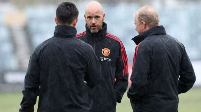 Manajer Manchester United, Erik ten Hag (tengah) berbincang dengan asisten pelatih Steve McClaren (kanan) dan pelatih set-piece Eric Ramsay. [Trevor Collens / AFP]