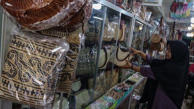 Penjual menata kerajinan tas rotan yang dijual di salah satu pusat oleh-oleh toko Permata Zahra, Palangka Raya, Kalimantan Tengah, Jumat (22/7/2022). ANTARA FOTO/Auliya Rahman