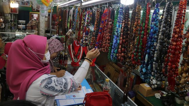 Pembeli memilih kerajinan pernak-pernik batu intan yang dijual di salah satu pusat oleh-oleh toko Permata Zahra, Palangka Raya Kalimantan Tengah, Jumat (22/7/2022).  ANTARA FOTO/Auliya Rahman