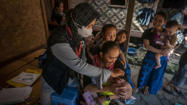 Bidan Puskesmas Cisimeut memberikan vaksin polio kepada seorang anak Suku Baduy Luar di Kampung Kaduketug, Lebak, Banten, Sabtu (23/7/2022). ANTARA FOTO/Muhammad Bagus Khoirunas


