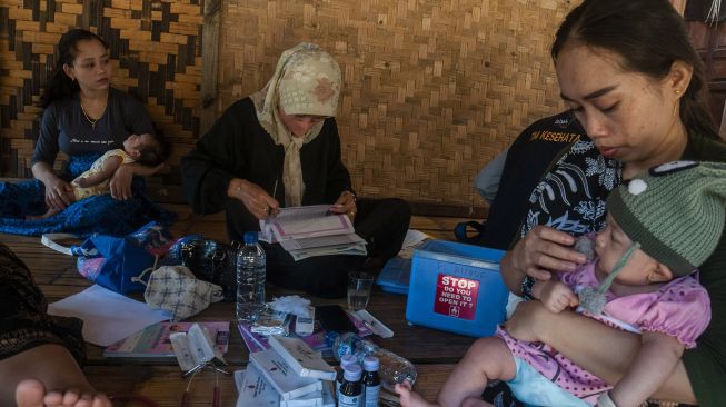 Bidan Puskesmas Cisimeut memberikan vaksin polio kepada seorang anak Suku Baduy Luar di Kampung Kaduketug, Lebak, Banten, Sabtu (23/7/2022). ANTARA FOTO/Muhammad Bagus Khoirunas


