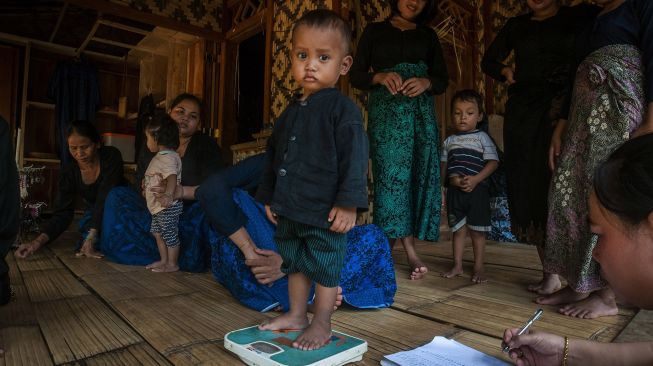 Kader posyandu menimbang berat badan anak Suku Baduy Luar saat jemput bola imunisasi anak di Kampung Kaduketug, Lebak, Banten, Sabtu (23/7/2022). ANTARA FOTO/Muhammad Bagus Khoirunas