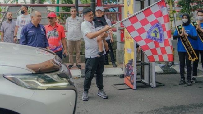 Wali Kota Medan Bobby Nasution sambil mengendong Panembahan Al Nahyan Nasution melepas peserta wisata reli di Balai Kota Medan, Sabtu (23/7/2022) [ANTARA/HO-Diskominfo Kota Medan]
