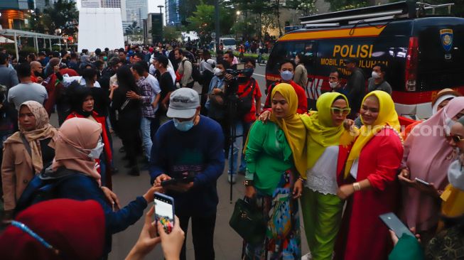 Keramaian warga melihat peragaan busana "Citayam Fashion Week" di kawasan Dukuh Atas, Jakarta Pusat, Senin (25/7/2022). [Suara.com/Alfian Winanto]