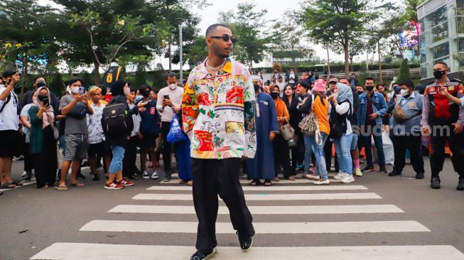 Warga berjalan di zebra cross saat peragaan busana "Citayam Fashion Week" di kawasan Dukuh Atas, Jakarta Pusat, Senin (25/7/2022). [Suara.com/Alfian Winanto]