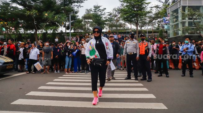 Warga berjalan di zebra cross saat peragaan busana "Citayam Fashion Week" di kawasan Dukuh Atas, Jakarta Pusat, Senin (25/7/2022). [Suara.com/Alfian Winanto]