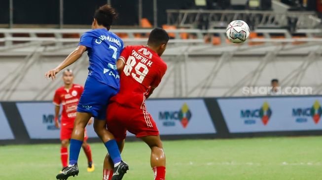 Pesepakbola Persija Jakarta Taufik Hidayat (kanan) berebut bola dengan pesepakbola Chonburi FC  Chatmongkol Rueang Thanarot (kiri) saat laga persahabatan dalam rangka Grand Launching Jakarta International Stadium (JIS) di Tanjung Priok, Jakarta Utara, Minggu (24/7/2022). [Suara.com/Alfian Winanto]