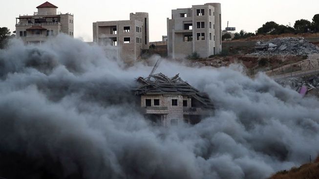 Bangunan milik warga Palestina dibom oleh pasukan Israel di desa Sur Baher yang berada di antara Yerusalem Timur dan Tepi Barat, Palestina, Senin (22/7/2019) waktu setempat. Militer Israel sering mengubah jalan dan lahan yang disitanya di wilayah pendudukan Palestina dengan dalih untuk digunakan buat tujuan militer dan pemukim Yahudi. ANTARA/REUTERS/Ammar Awad/aa