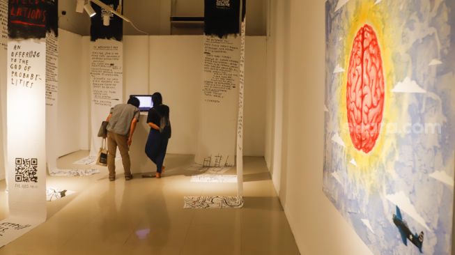 Pengunjung melihat karya seni rupa di Pameran Manifesto VIII : Transposisi di Galeri Nasional, Jakarta Pusat, Selasa (26/7/2022). [Suara.com/Alfian Winanto]