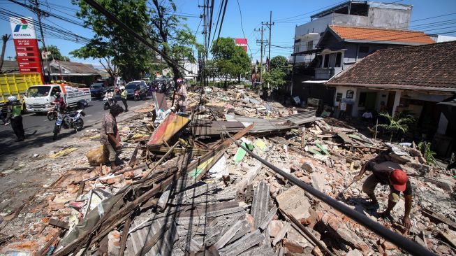 Warga mencari sisa barang yang masih berharga di lokasi pembongkaran bangunan di kawasan simpang Aloha, Sidoarjo, Jawa Timur, Rabu (27/7/2022).  ANTARA FOTO/Umarul Faruq

