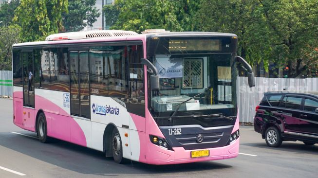 Bus pink Transjakarta saat melintas di Pasar Baru, Jakarta Pusat, Rabu (27/7/2022). [Suara.com/Alfian Winanto]