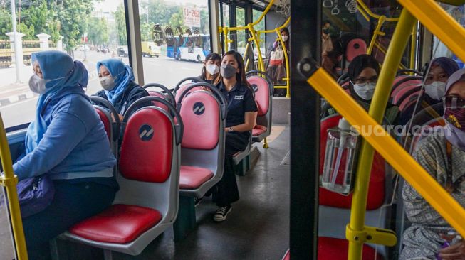 Penumpang menaiki bus pink Transjakarta di Halte Pasar Baru, Jakarta Pusat, Rabu (27/7/2022). [Suara.com/Alfian Winanto]