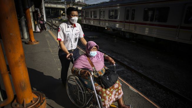 Petugas membantu penumpang di Stasiun Karet, Jakarta, Kamis (28/7/2022).  ANTARA FOTO/Rivan Awal Lingga