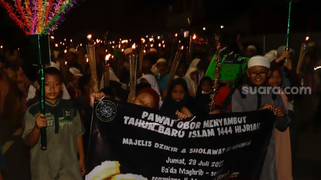 Umat muslim mengikuti pawai obor menyambut Tahun Baru Islam di kawasan Manggarai, Jakarta Selatan, Jumat (29/7/2022). [Suara.com/Alfian Winanto]