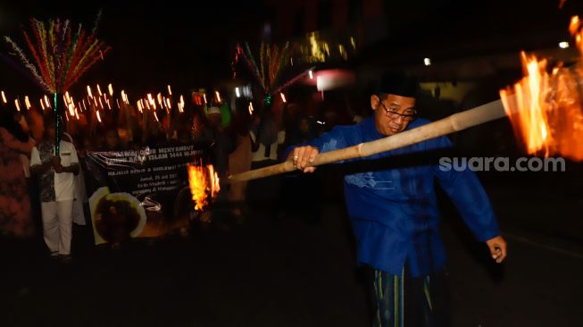 Umat muslim mengikuti pawai obor menyambut Tahun Baru Islam di kawasan Manggarai, Jakarta Selatan, Jumat (29/7/2022). [Suara.com/Alfian Winanto]