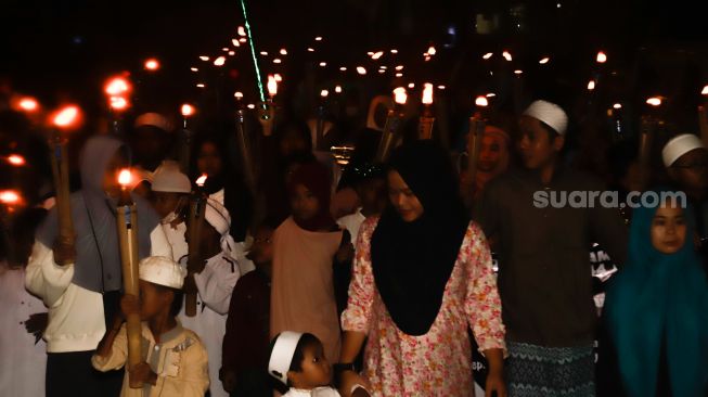 Umat muslim mengikuti pawai obor menyambut Tahun Baru Islam di kawasan Manggarai, Jakarta Selatan, Jumat (29/7/2022). [Suara.com/Alfian Winanto]