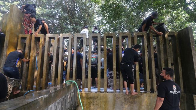 Sejumlah peziarah membersihkan petilasan Sri Aji Jayabaya saat pencucian batu manik yang dikeramatkan di Desa Menang, Kediri, Jawa Timur, Jumat (29/7/2022).  ANTARA FOTO/Prasetia Fauzani