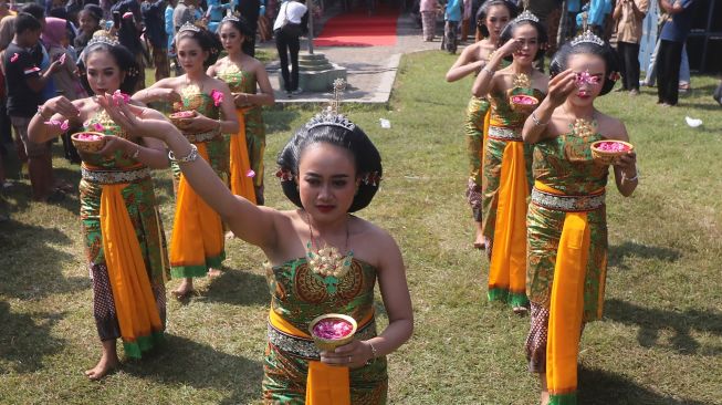 Peserta Kirab Ritual Agung Jayabaya menabur bunga di kawasan petilasan raja Sri Aji Jayabaya, Desa Menang, Kediri, Jawa Timur, Sabtu (30/7/2022). ANTARA FOTO/Prasetia Fauzani
