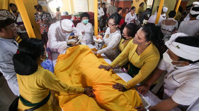 Umat Hindu mengikuti prosesi upacara potong gigi massal di Pura Jala Siddhi Amertha, Juanda, Sidoarjo, Jawa Timur, Sabtu (30/7/2022).  ANTARA FOTO/Umarul Faruq