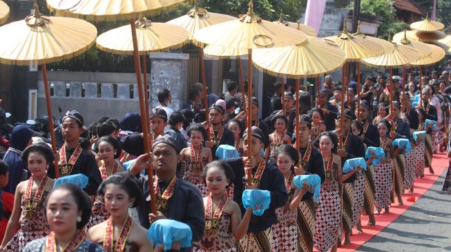 Sejumlah remaja membawa sesaji saat mengikuti Kirab Ritual Agung Jayabaya di kawasan petilasan raja Sri Aji Jayabaya, Desa Menang, Kediri, Jawa Timur, Sabtu (30/7/2022).  ANTARA FOTO/Prasetia Fauzani
