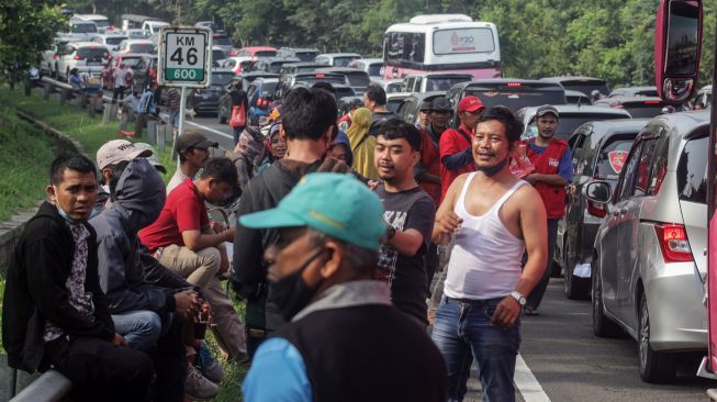 Wisatawan keluar dari kendaraan saat menunggu antrean panjang kendaraan menuju kawasan wisata Puncak, Gadog, Kabupaten Bogor, Jawa Barat, Sabtu (30/7/2022). ANTARA FOTO/Yulius Satria Wijaya