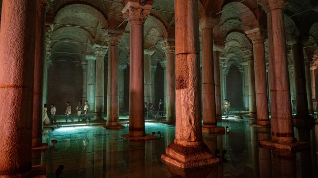 Orang-orang mengunjungi situs bersejarah Basilica Cistern di Istanbul, Turki, Selasa (26/7/2022). [Yasin AKGUL/AFP]