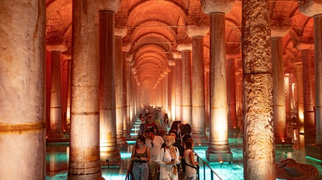 Orang-orang mengunjungi situs bersejarah Basilica Cistern di Istanbul, Turki, Selasa (26/7/2022). [Yasin AKGUL/AFP]