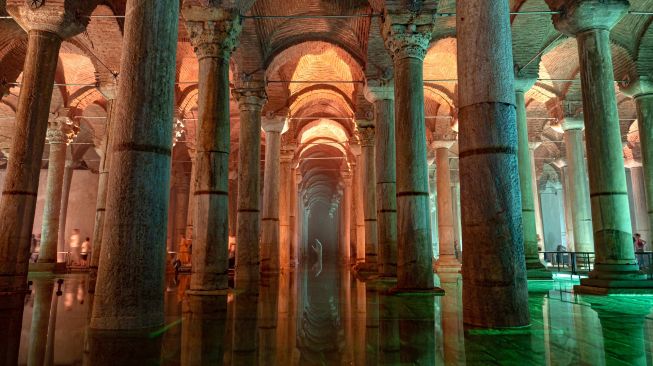 Orang-orang mengunjungi situs bersejarah Basilica Cistern di Istanbul, Turki, Selasa (26/7/2022). [Yasin AKGUL/AFP]