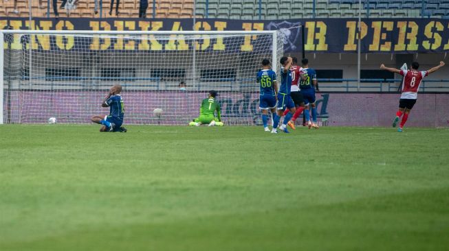 Pesepak bola Persib Bandung David Da Silva (kiri) dan penjaga gawang Fitrul Dwi Rustapa (kedua kiri) menutup wajah usai kebobolan oleh tim Madura United saat pertandingan BRI Liga 1 di Stadion Gelora Bandung Lautan Api, Bandung, Jawa Barat, Sabtu (30/7/2022). [ANTARA FOTO/M Agung Rajasa/hp]
