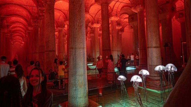 Orang-orang mengunjungi situs bersejarah Basilica Cistern di Istanbul, Turki, Selasa (26/7/2022). [Yasin AKGUL/AFP]