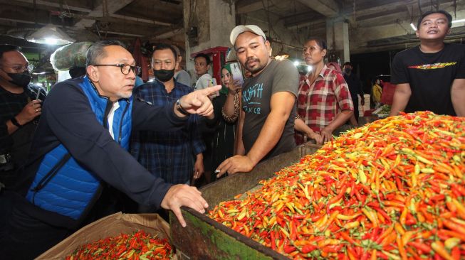 Menteri Perdagangan Zulkifli Hasan (kedua kiri) berbincang dengan pedagang saat melakukan kunjungan di Pasar Keputran Surabaya, Jawa Timur, Sabtu (30/7/2022).  ANTARA FOTO/Didik Suhartono
