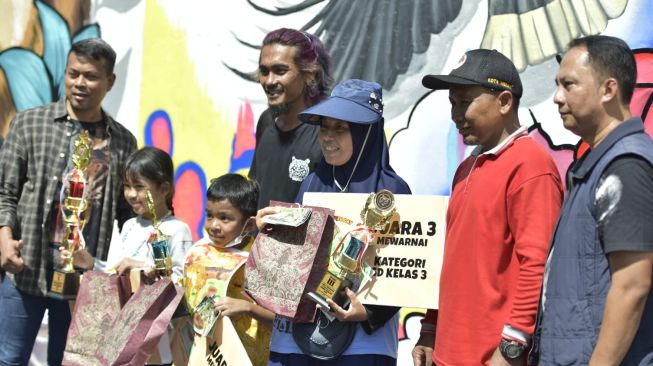 Panitia berfoto bersama dengan pemenang lomba mewarnai. [Ist]