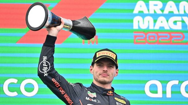 Pebalap Red Bull Racing, Max Verstappen mengangkat trofi usai menjuarai F1 GP Hungaria 2022 di Sirkuit Hungaroring, Budapest, Minggu (31/7/2022) malam WIB. [Attila KISBENEDEK / AFP]