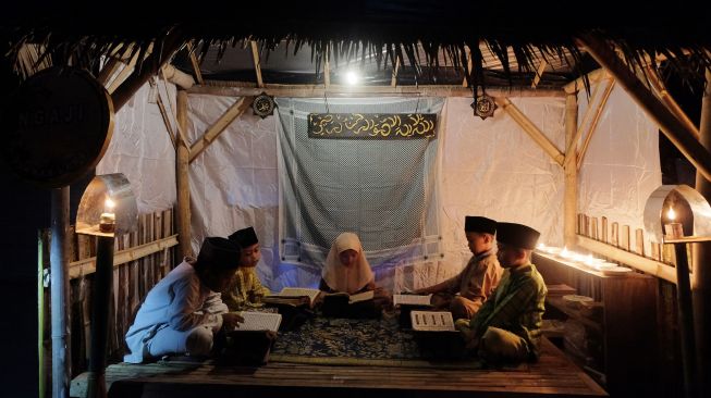 Sejumlah anak menampilkan tradisi ngaji saat Festival Budaya Loloan Djaman Lame di Kampung Loloan, Jembrana, Bali, Sabtu (30/7/2022). [ANTARA FOTO/Nyoman Hendra Wibowo/hp]