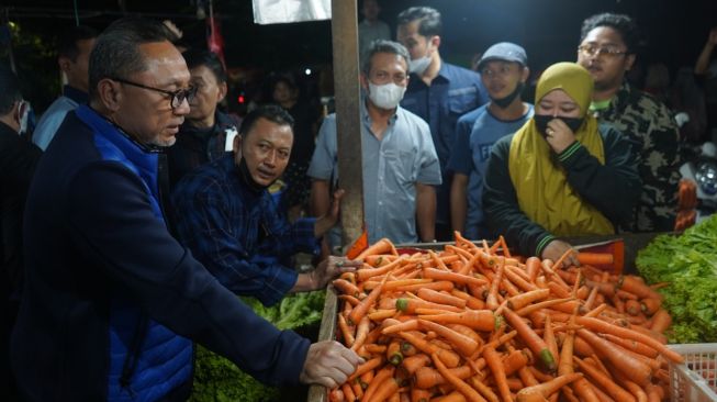 Menteri Perdagangan Zulkifli Hasan (kedua kiri) berbincang dengan pedagang saat melakukan kunjungan di Pasar Keputran Surabaya, Jawa Timur, Sabtu (30/7/2022).