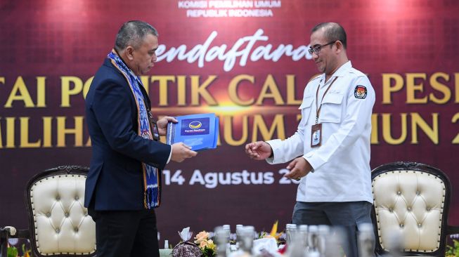 Ketua Komisi Pemilihan Umum (KPU) Hasyim Asy'ari (kanan) bersiap menerima berkas pendaftaran dari Wakil Ketua Umum Partai NasDem Ahmad Ali (kiri) saat Pendaftaran Partai Politik Calon Peserta Pemilu tahun 2024 di Kantor KPU, Jakarta, Senin (1/8/2022). [ANTARA FOTO/M Risyal Hidayat/nym]