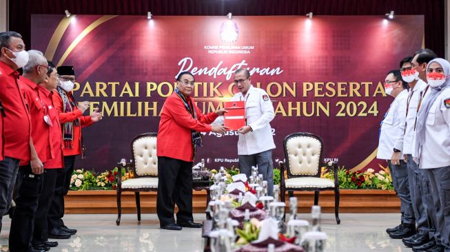 Ketua Komisi Pemilihan Umum (KPU) Hasyim Asy'ari (kanan) menerima berkas pendaftaran dari Ketua DPP PDI Perjuangan Bidang Pemenangan Pemilu Bambang Wuryanto (kiri) saat Pendaftaran Partai Politik Calon Peserta Pemilu tahun 2024 di Kantor KPU, Jakarta, Senin (1/8/2022). [ANTARA FOTO/M Risyal Hidayat/nym]
