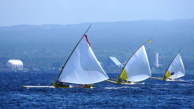 Nelayan memacu perahu layarnya pada perlombaan yang digelar di Selat Bali, Gilimanuk, Jembrana, Bali, Minggu (31/7/2022). [ANTARA FOTO/Budi Candra Setya/wsj]