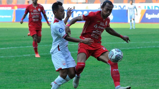 Pesepak bola Persija Jakarta Hansamu Yama (kanan) menghalangi pergerakan pesepak bola Persis Solo Samsul Arif (kiri) pada lanjutan Liga 1 di Stadion Patriot Chandrabhaga, Bekasi, Jawa Barat, Minggu (31/7/2022). [ANTARA FOTO/Fakhri Hermansyah/wsj]