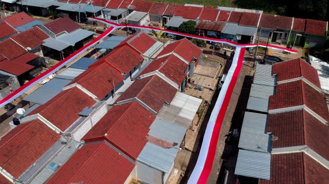 Foto udara bentangan kain merah putih yang dipasang warga di Perumahan Mutiara Tragung, Kecamatan Kandeman, Kabupaten Batang, Jawa Tengah, Senin (1/8/2022). [ANTARA FOTO/Harviyan Perdana Putra/nym