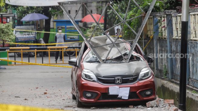 Sebuah mobil tertimpa besi akibat robohnya tembok proyek revitalisasi Gelanggang Olah Raga (GOR) Mampang di Pela Mampang, Jakarta Selatan, Selasa (2/8/2022). [Suara.com/Alfian Winanto]. 