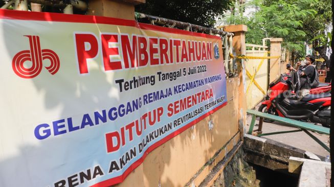 Garis polisi terpasang di pintu pagar Gelanggang Olahraga (GOR) Mampang setelah peristiwa robohnya tembok proyek revitalisasi di Pela Mampang, Jakarta Selatan, Selasa (2/8/2022). [Suara.com/Alfian Winanto]