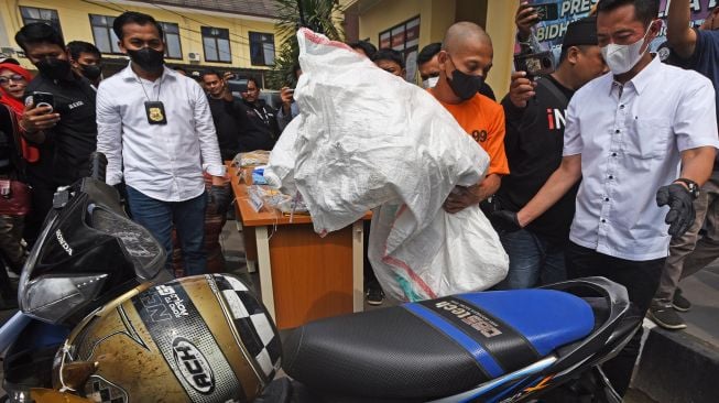 Tersangka pembunuhan berinisial TW (kedua kanan) memperagakan pembuangan karung berisi mayat saat ekspos ungkap kasus pembunuhan di Mapolda Banten, di Serang, Banten, Selasa (2/8/2022).  ANTARA FOTO/Asep Fathulrahman