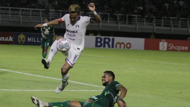 Kapten Persita Tangerang Mohammad Toha melompat untuk menghindari tekel Silvio Junior pada pertandingan Persebaya vs Persita di Stadion Gelora Bung Tomo Surabaya, Senin (1/8/2022) malam. ANTARA/Moch Asim.