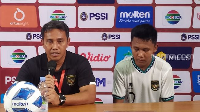 Bima Sakti dan pemain timnas Indonesia U-16, Nabil Asyura saat jumpa pers setelah pertandingan melawan Singapura U-16 di Stadion Maguwoharjo, Sleman pada Rabu (3/8/2022). (Suara.com/Arif Budi)