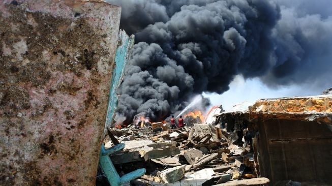 Petugas pemadam kebakaran memadamkan api saat terjadi kebakaran rongsokan perahu dan kapal di Pelabuhan Panarukan, Situbondo, Jawa Timur, Kamis (4/8/2022).  ANTARA FOTO/Seno